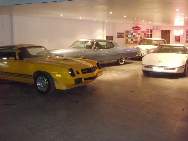 A Chevrolet Camaro, classic sedan and Corvette together in the showroom
