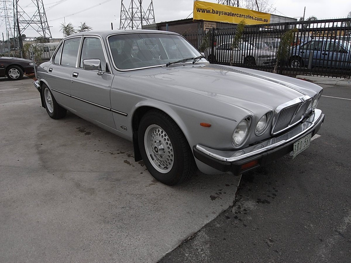 A Jaguar XJ6 parked at Bayswater Car Sales with a banner reading www.bayswatercarsales.com.au